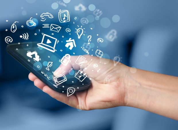 Hand holding smartphone with media icons and symbol collection