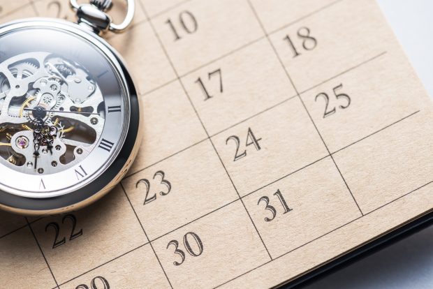 Pocket watch on calendar.