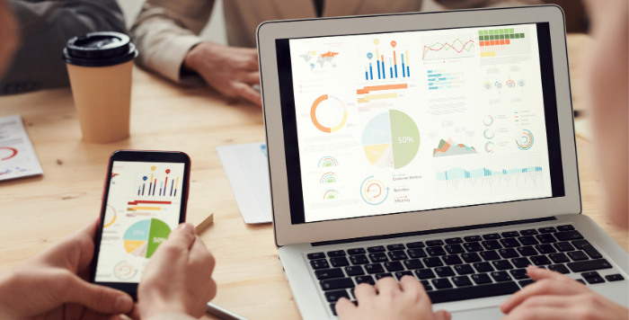 スマートフォンとパソコンでデータを確認する人たち